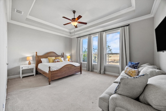 bedroom with a tray ceiling, ceiling fan, crown molding, and light colored carpet