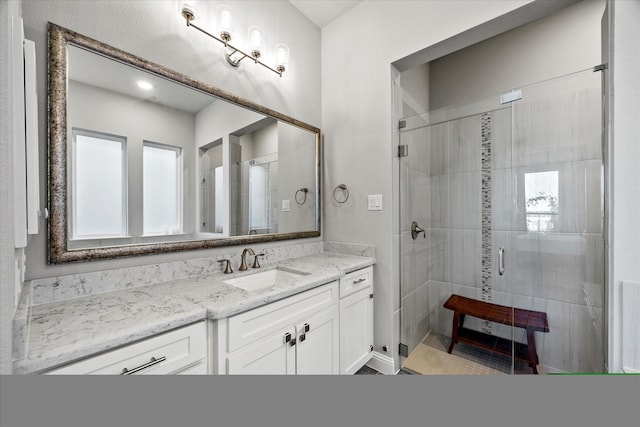 bathroom featuring vanity and a shower with door