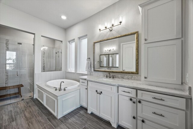 bathroom with shower with separate bathtub and vanity