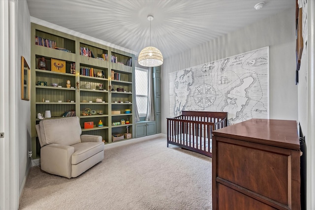 carpeted bedroom with ornamental molding, a nursery area, and an inviting chandelier