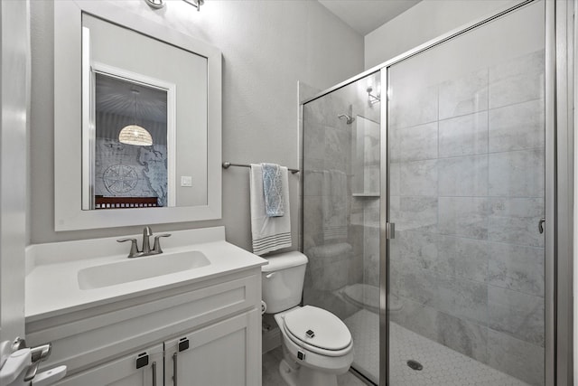 bathroom with vanity, toilet, and a shower with shower door