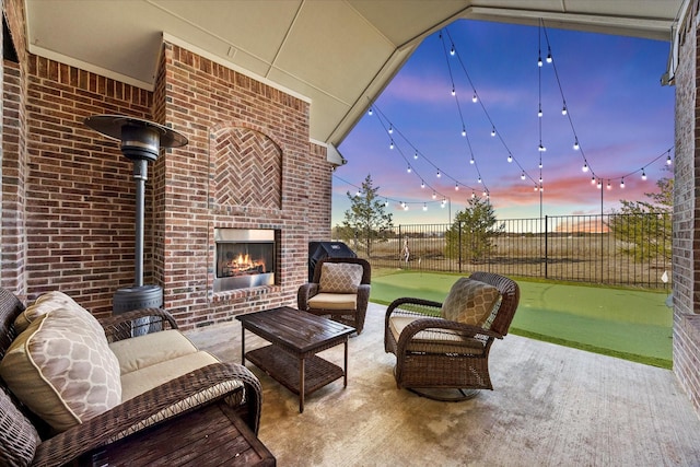 patio terrace at dusk featuring an outdoor living space with a fireplace