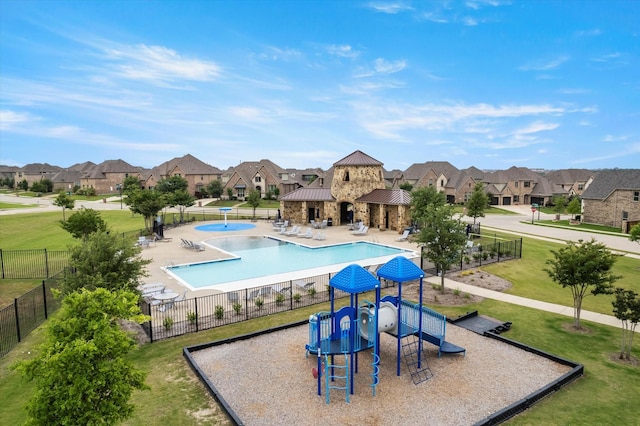 view of swimming pool featuring a patio, a playground, and a lawn