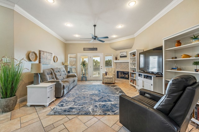 tiled living room featuring crown molding, ceiling fan, and a tiled fireplace