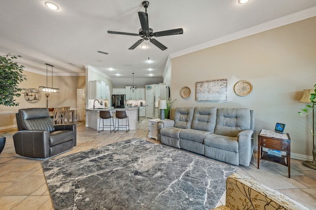 living room with crown molding, sink, and ceiling fan