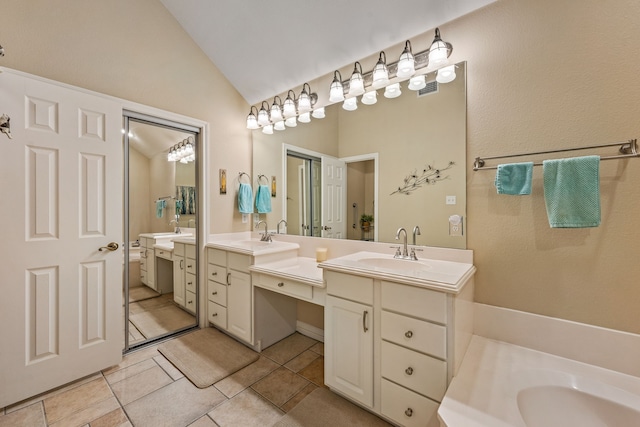 bathroom with lofted ceiling, vanity, and tile patterned floors