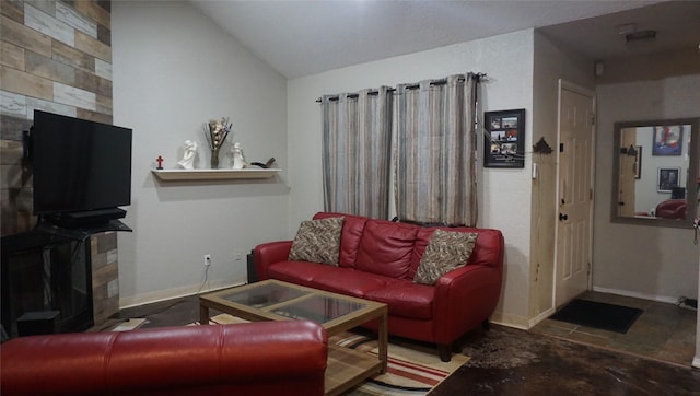 living room with a tile fireplace and lofted ceiling