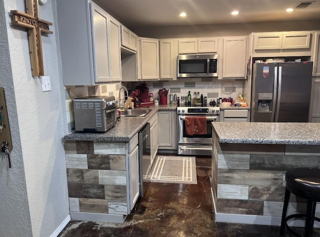 kitchen with appliances with stainless steel finishes, white cabinetry, and sink