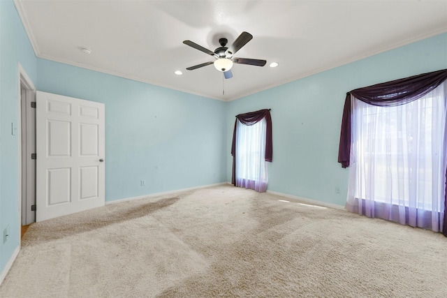 spare room with ceiling fan, ornamental molding, and light carpet