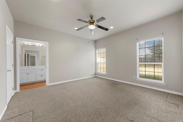 unfurnished bedroom featuring carpet flooring, ensuite bath, and ceiling fan