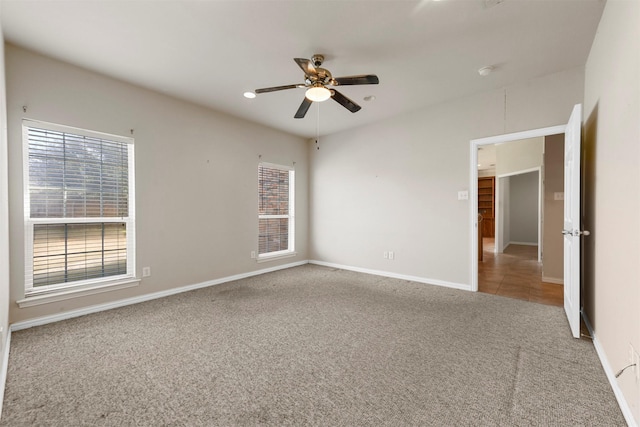 spare room with ceiling fan and carpet