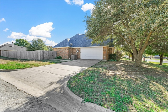 view of front of property with a garage, a front lawn, and central air condition unit