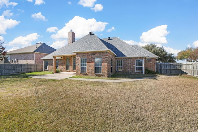 back of property with a patio area and a yard