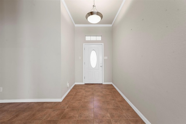 foyer entrance featuring crown molding and dark tile patterned flooring