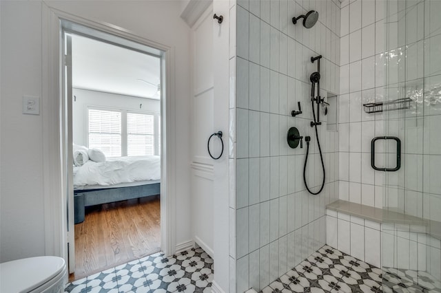 bathroom featuring hardwood / wood-style flooring, toilet, and a shower with door