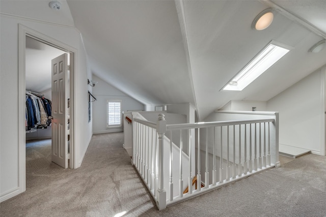 hall featuring light carpet and vaulted ceiling with skylight