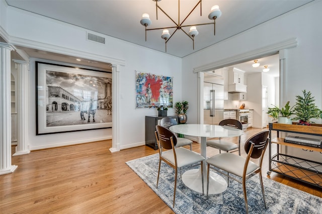 dining room with light hardwood / wood-style flooring and a chandelier