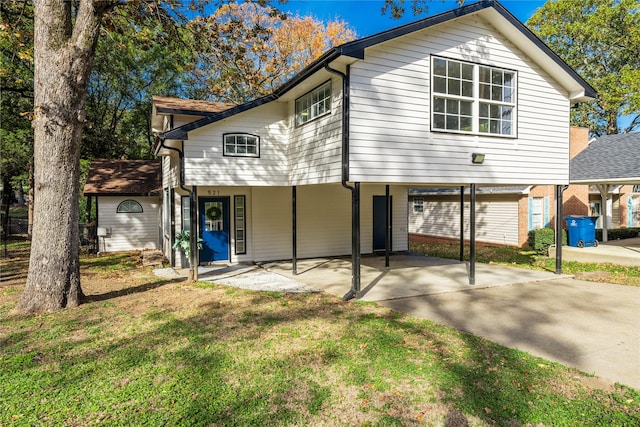 rear view of property featuring a carport and a yard