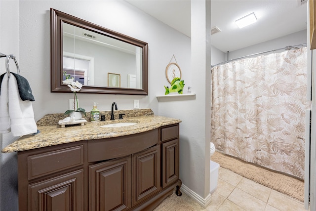 bathroom with tile patterned flooring, vanity, and toilet