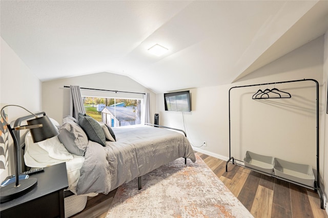 bedroom featuring dark hardwood / wood-style flooring and vaulted ceiling