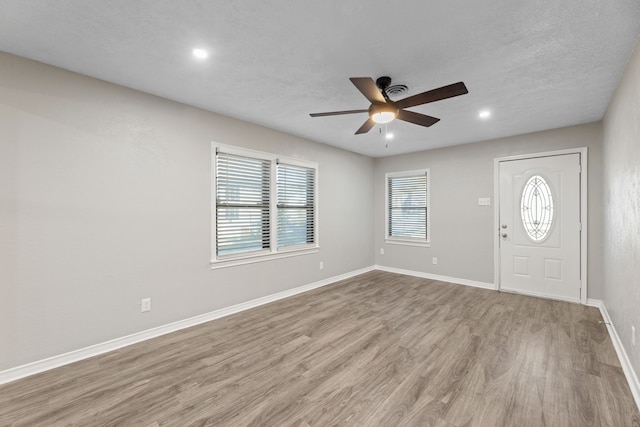 foyer entrance featuring ceiling fan, light hardwood / wood-style floors, and a textured ceiling