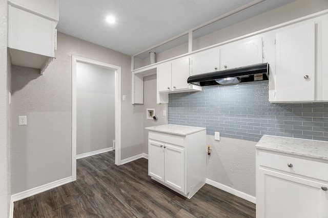 kitchen with white cabinets, dark hardwood / wood-style flooring, and backsplash