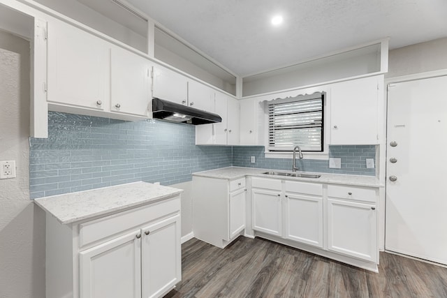 kitchen featuring dark hardwood / wood-style flooring, white cabinetry, sink, and decorative backsplash