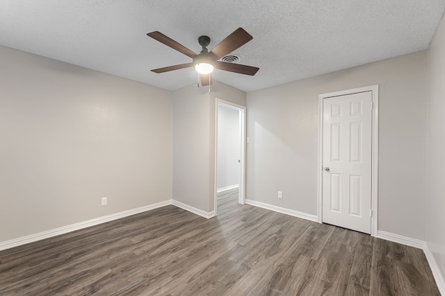 unfurnished room with a textured ceiling, dark hardwood / wood-style floors, and ceiling fan