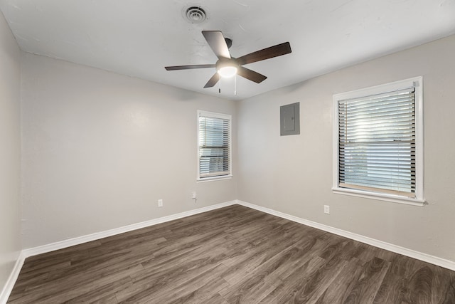 unfurnished room featuring electric panel, ceiling fan, and dark hardwood / wood-style flooring