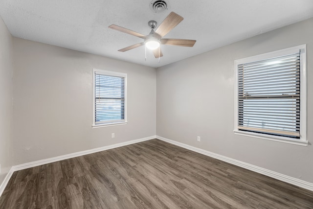 spare room with a textured ceiling, ceiling fan, and dark hardwood / wood-style floors