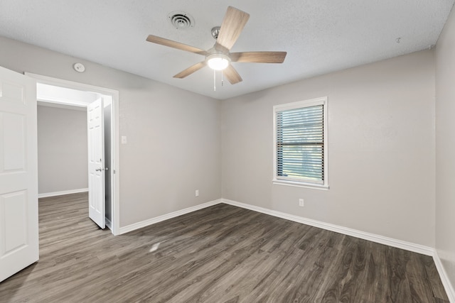 unfurnished room featuring ceiling fan, dark wood-type flooring, and a textured ceiling