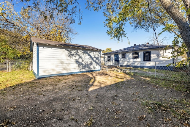 rear view of property with a storage shed