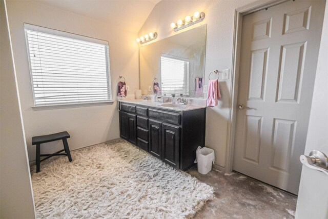 bathroom with concrete flooring, vanity, and lofted ceiling