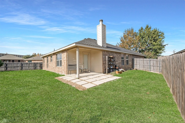 rear view of house featuring a patio area and a yard