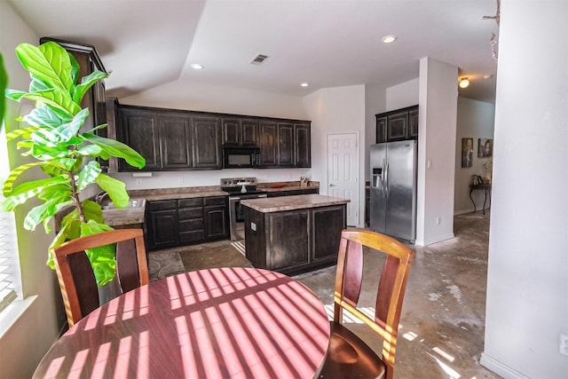 kitchen featuring dark brown cabinets, a center island, stainless steel appliances, and lofted ceiling