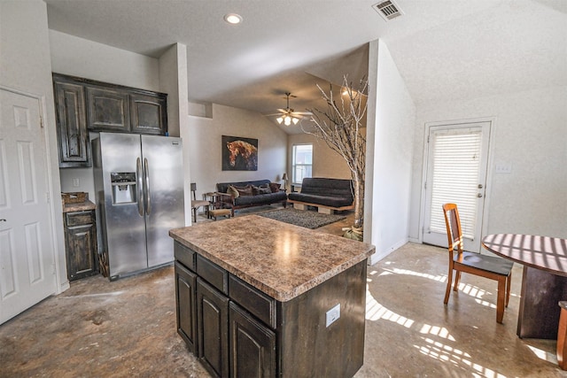 kitchen featuring ceiling fan, stainless steel refrigerator with ice dispenser, vaulted ceiling, dark brown cabinets, and a kitchen island