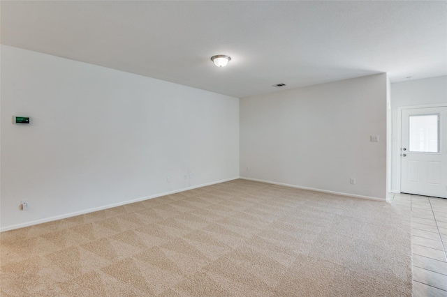 unfurnished room featuring light carpet