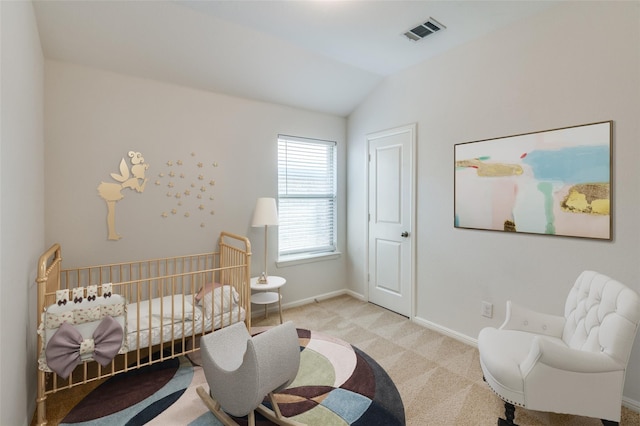 carpeted bedroom featuring lofted ceiling and a nursery area