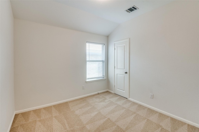 carpeted empty room with lofted ceiling