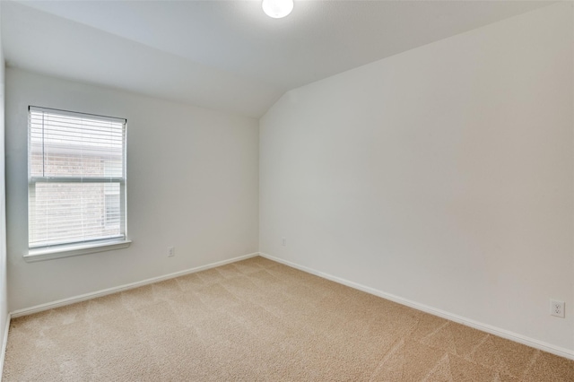 unfurnished room featuring light colored carpet and vaulted ceiling