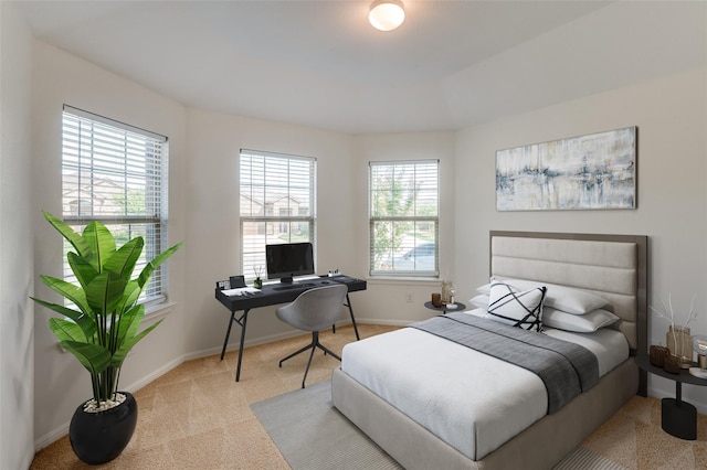 bedroom with light colored carpet and multiple windows