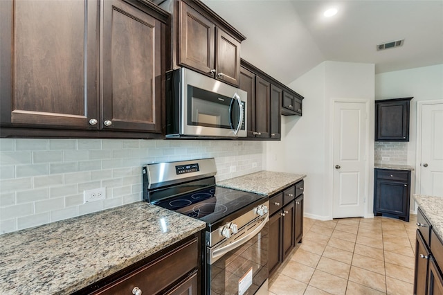 kitchen featuring dark brown cabinetry, stainless steel appliances, light stone counters, decorative backsplash, and light tile patterned floors