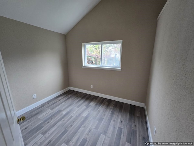 empty room featuring hardwood / wood-style floors and lofted ceiling