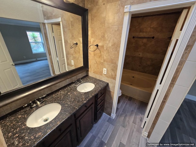 full bathroom featuring hardwood / wood-style floors, vanity, tile walls, and toilet