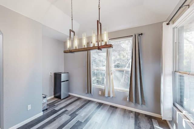 unfurnished dining area featuring plenty of natural light and dark hardwood / wood-style flooring