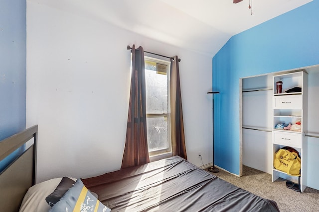 carpeted bedroom with a closet and vaulted ceiling