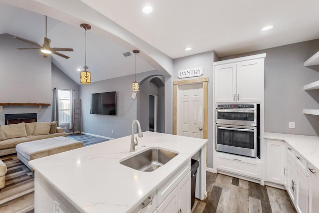 kitchen featuring white cabinetry, sink, stainless steel double oven, dark hardwood / wood-style flooring, and vaulted ceiling