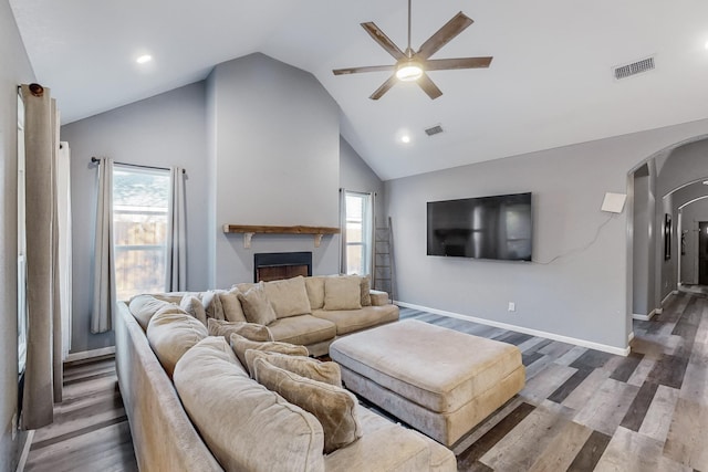 living room featuring high vaulted ceiling, ceiling fan, dark wood-type flooring, and a wealth of natural light