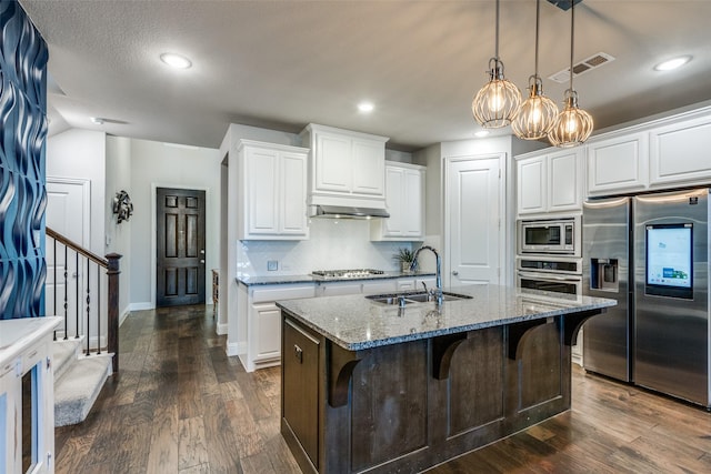 kitchen featuring light stone countertops, stainless steel appliances, white cabinetry, and sink