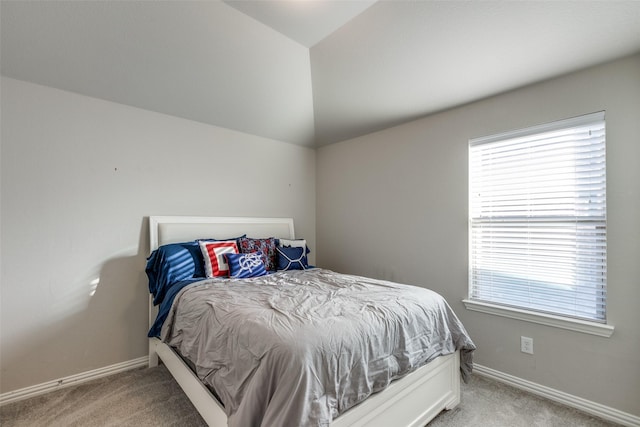 bedroom featuring vaulted ceiling, light colored carpet, and baseboards